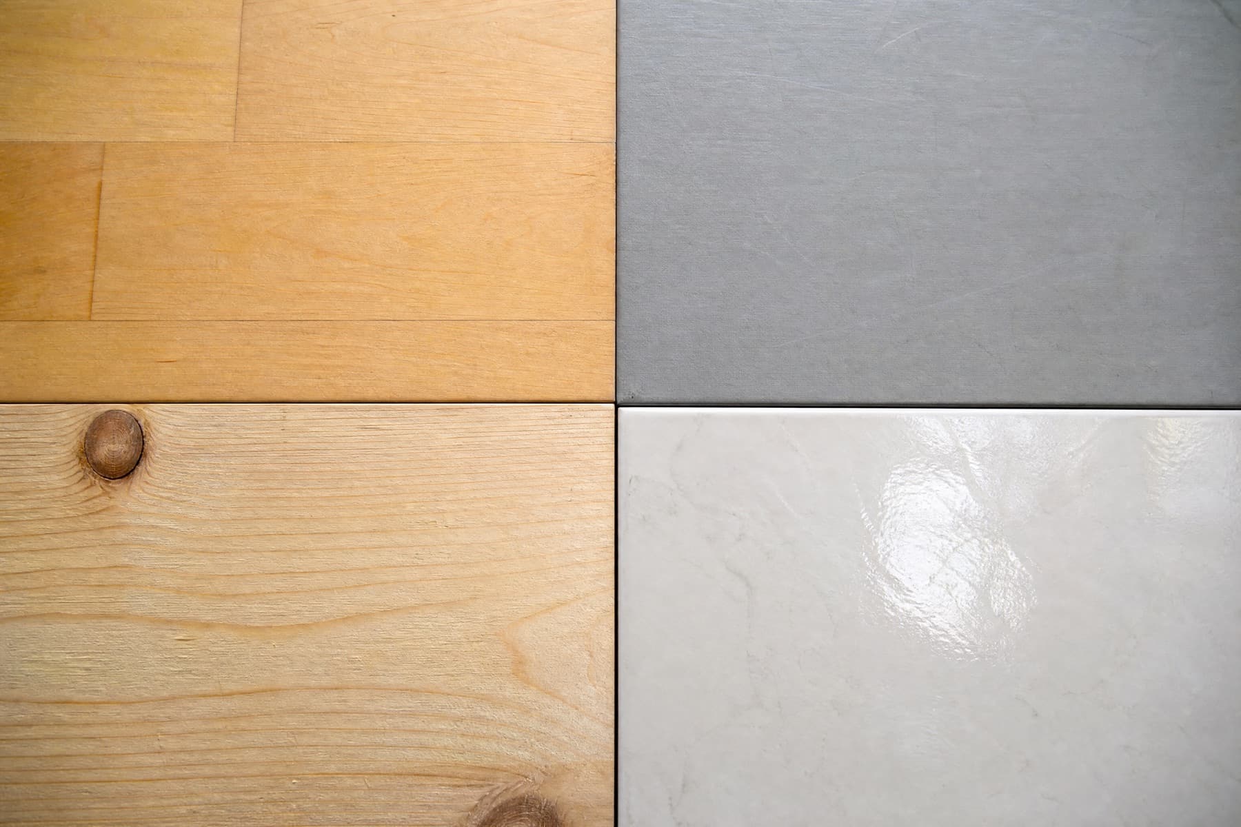 Macro of four dance floor surfaces meeting: sprung maple, vinyl marley, raw pine and porcelain tile