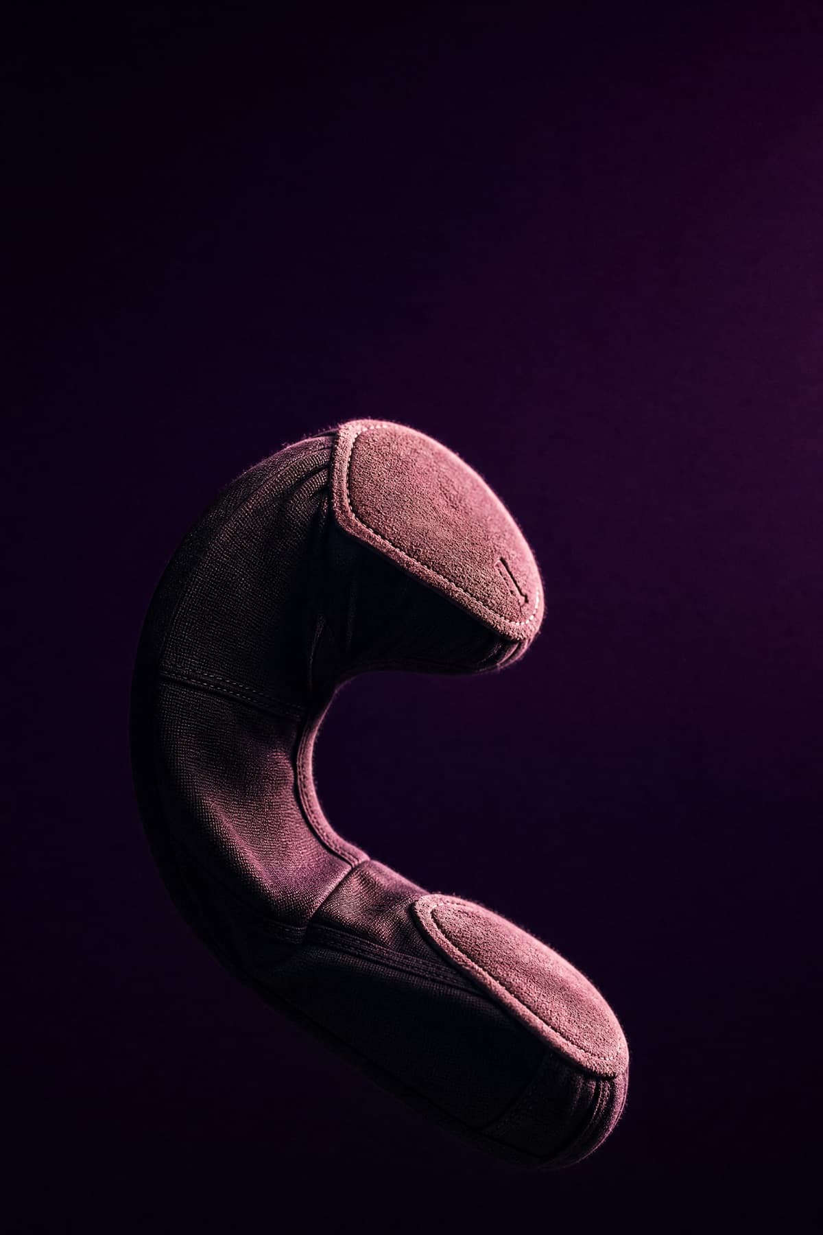 A split-sole ballet slipper bent deeply at the arch, the two suede sole pads lifting apart